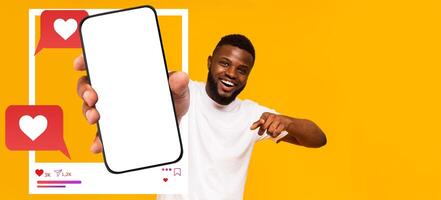An influencer displays a smartphone with a blank screen, emphasizing social media interaction. The background is vibrant yellow, creating an inviting atmosphere for digital communication. photo