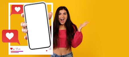An enthusiastic influencer excitedly holds a smartphone displaying a blank screen for a social media application. photo
