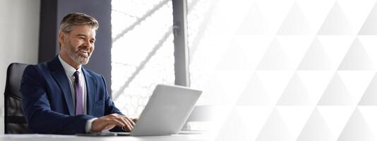 Handsome middle aged businessman in suit working with laptop in modern office, smiling confident man entrepreneur sitting at desk and typing on keyboard, using computer at workplace, copy space photo