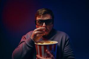 A man is watching a scary movie. Watching a movie with popcorn. photo