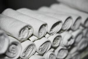 Rolled white towels stacked in a spa for relaxation and comfort photo