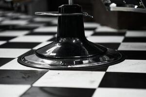Black and white checkerboard floor with a chair base in a diner setting photo