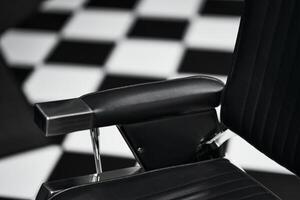 Black and white checkered floor with a modern barber chair at a salon photo