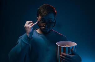 Man with surprised expression and popcorn. Emotion while watching a movie. photo