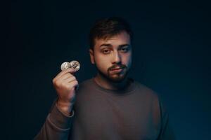 A young man with a bitcoin in his hands. Cryptocurrency. photo