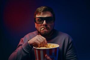 A man is watching a scary movie. Watching a movie with popcorn. photo