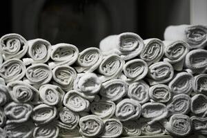Neatly rolled white towels stacked for display in a spa environment photo