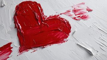 A red heart with red paint on it is on a white background photo