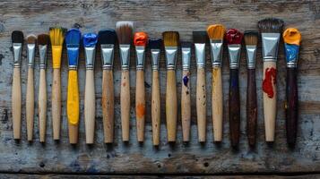 A row of paint brushes on a wooden table photo