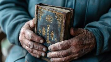Old hands holding a bible photo