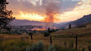 A fire burns in the mountains at sunset photo