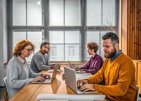 group of people working on laptops in office photo
