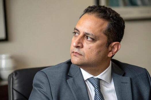 man in a suit and tie sitting in an office photo