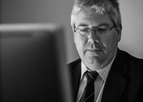 a man in a suit and tie looking at a computer screen photo