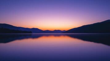 As the day ends, the sky is painted in vibrant hues of orange and purple, casting a serene glow over the tranquil lake and surrounding mountains photo