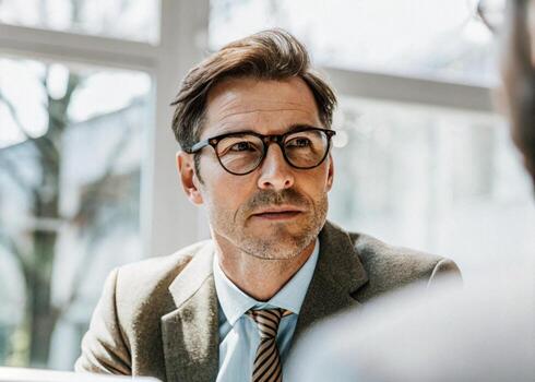 a man in glasses is talking to another man photo