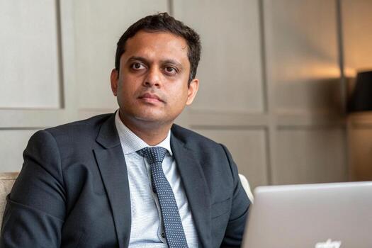a man in a suit and tie sitting in front of a laptop photo