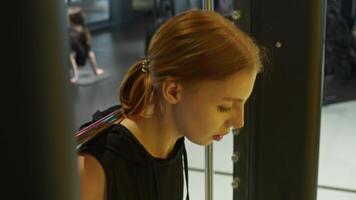 Graceful and feminine redhead performs challenging exercises, including deadlifts and squats, loading her shoulders with heavy barbell at gym. video
