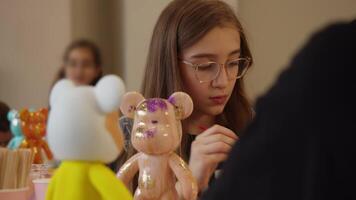 A teenager was focused during an art class, coloring a statuette and communicating with her classmates. video