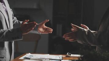 Two business people shaking hands at a table video