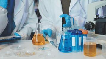 Two people in lab coats and gloves are working on a project video