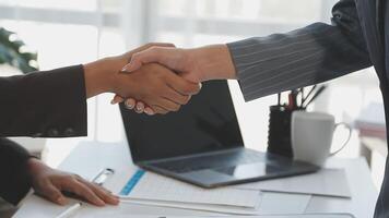 Two business people shaking hands over a desk video