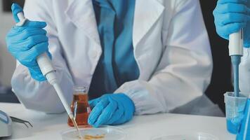 Two people in lab coats and gloves are working on a project video