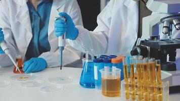 Two people in lab coats working on a project video