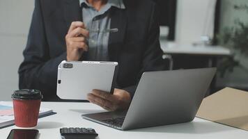A man in a suit holding a tablet computer video