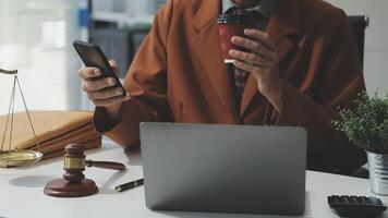 A man in a suit holding a cup of coffee and a laptop video