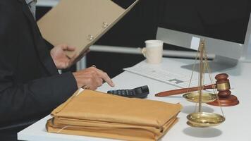 A man in a suit is working on a laptop and a scale video