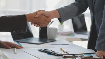 Two business people shaking hands over a desk video