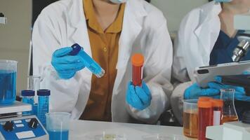 Two people in lab coats and gloves are working on a project video