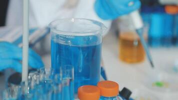 A person in a lab coat is holding a test tube video