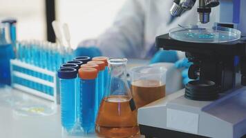 A person in a lab coat is looking at a microscope video