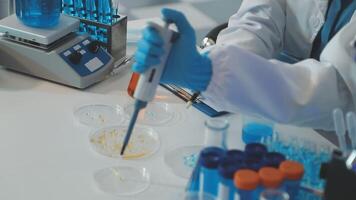 A person in a lab coat is working on a test tube video