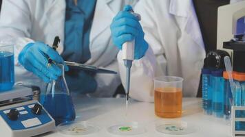 A person in a lab coat is working on a test tube video