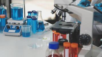 A person in a lab coat is working on a microscope video