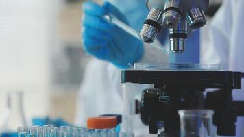 A person in a lab coat is looking at a microscope video