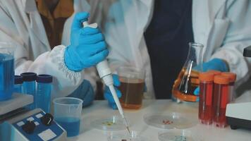 Two people in lab coats and gloves are working on a project video