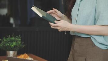 A woman is reading a book while sitting at a table video