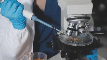 A person in blue gloves is holding a microscope video