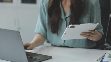 A woman is using a tablet and laptop computer video