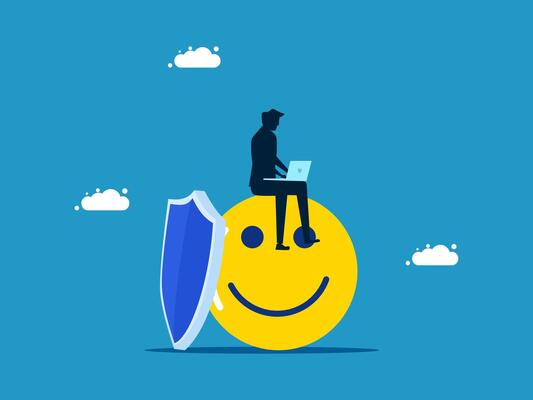 a man sitting on top of a smiley face with a laptop