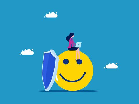 woman sitting on top of a smiley face with a laptop