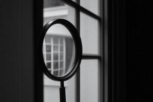 A magnifying glass resting by a window. photo