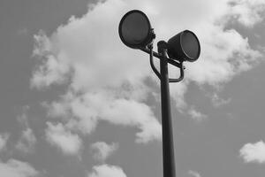 A black and white image of a streetlight against clouds. photo