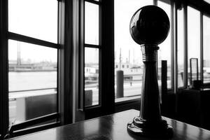 A black and white image of a nautical signal device indoors. photo