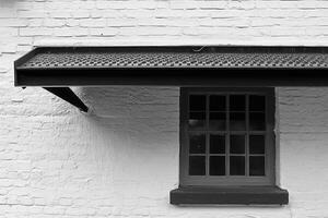 A close-up of a window and overhanging roof. photo