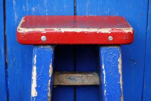 A colorful stool against a blue backdrop. photo